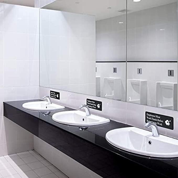 Restaurant restroom displaying 'Employees Must Wash Hands' sign near sinks, promoting hygiene and food safety.