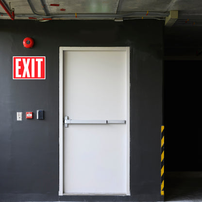 Photoluminescent exit sign sticker installed on a warehouse door. This exit door signage provides clear markings for safe evacuation during emergencies, especially in low-light situations