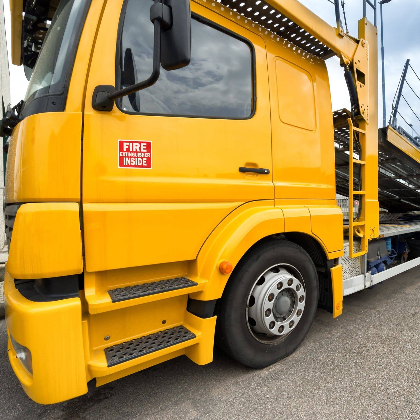 Fire extinguisher inside sign on a yellow truck ensuring compliance with safety regulations