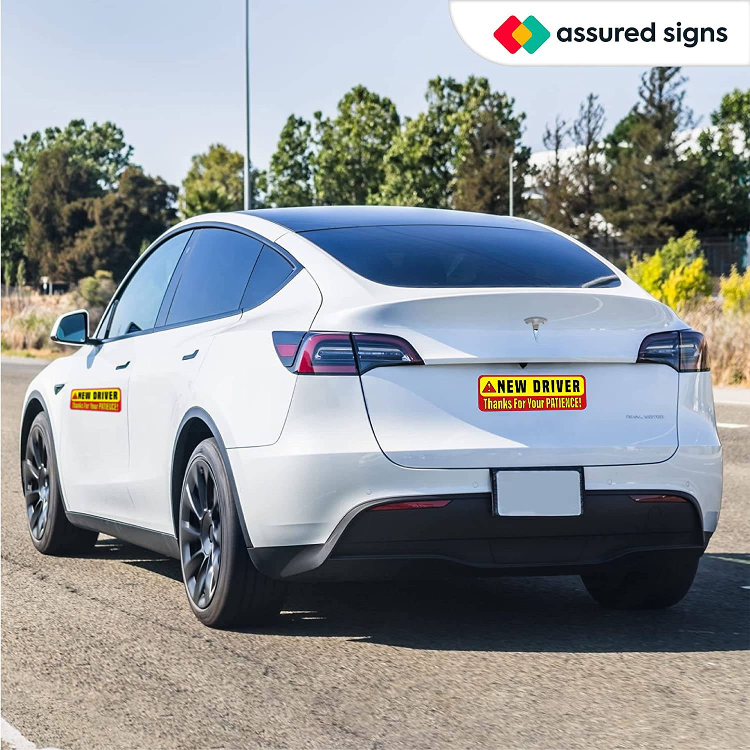 New driver car magnet sign applied to a Tesla, promoting caution and patience for surrounding drivers with its bright yellow and red reflective design