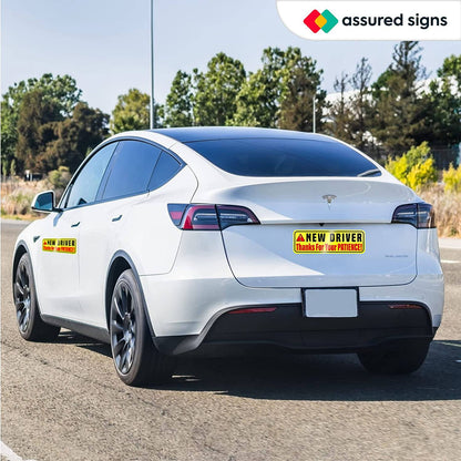 New driver sign displayed on the back of a Tesla, highlighting its bright reflective design that promotes caution for other drivers