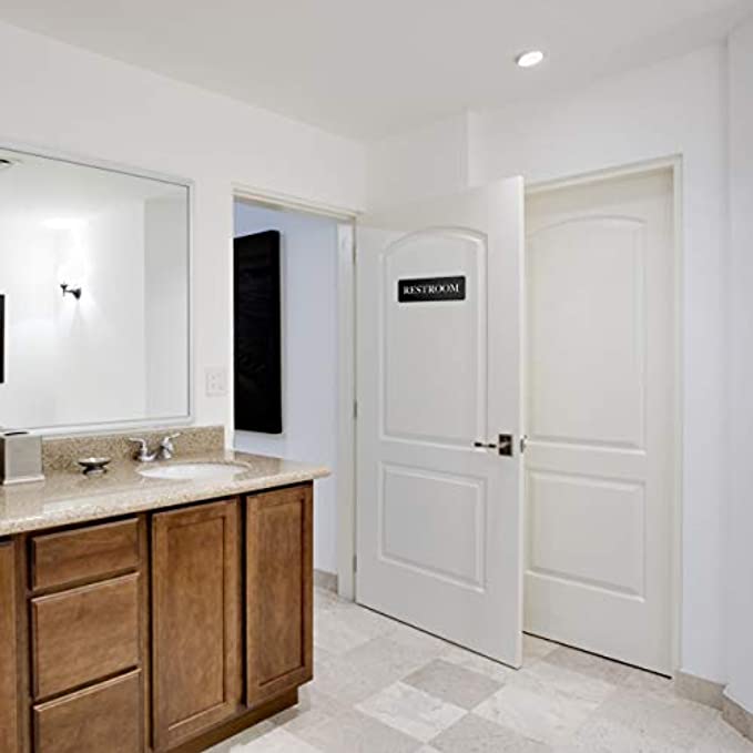 Restroom sign affixed on a door in a modern bathroom setting, providing clear direction to the toilet