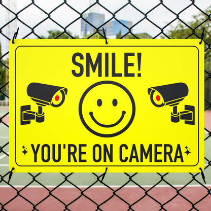 Smile You're On Camera Sign mounted on a fence using cable ties, providing security and deterring shoplifting and other unlawful activities