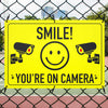 smile you're on camera sign on wire fence